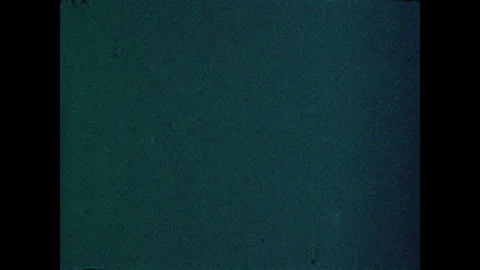 1950s: Electric charge flows between two objects as a man, standing before a Stock Footage 84860108