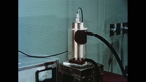1950s: Engineer drains oil from engine in factory lab. Machines draw on graph Stock Footage 165426978