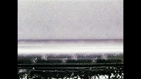 1950s: Engraved rollers print designs on fabric. Cotton fabric runs through hot Stock Footage 104729539