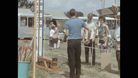 1950s: Film slate. Man playing strong man carnival game. A piece of clothing on Stock Footage 165356471