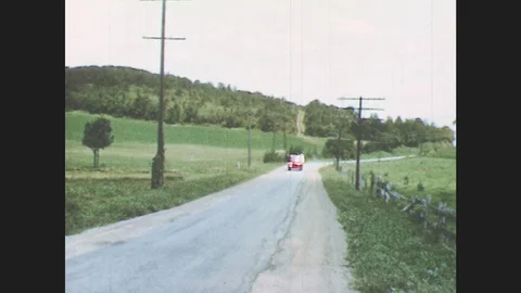 1950s: Fire truck drives down rural road with people holding onto outer sides. Stock Footage 79815638
