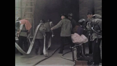1950s: Firefighters rescue students from inside burning school. Paramedics pull Stock Footage 237700467