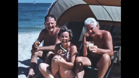 1950s Florida Beach: Two Men and Woman Laughing with Drinks, Sunny Day (2K) Stock Footage 314914388