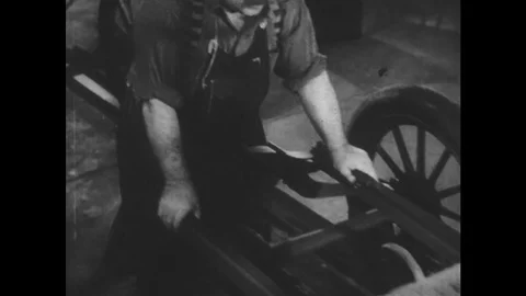 1950s: Ford workmen work on assembly line. Men attach components to car on Stock Footage 74812653