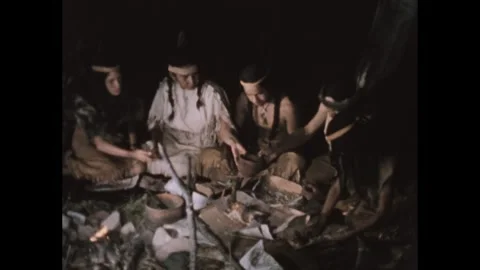 1950s: Group of Native Americans sitting around the fire and sharing a meal. Stock Footage 306387032