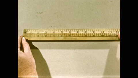 1950s: Hand grasps ruler. Window sill. Person places yardstick on windowsill. Vídeo Stock 169182517