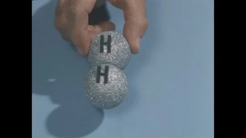 1950s: hand holds two connected gray styrofoam balls, turns them over to reveal Stock Footage 279488532