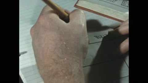 1950s: Hand with pencil writes on comparison chart. Stock Footage 189953121