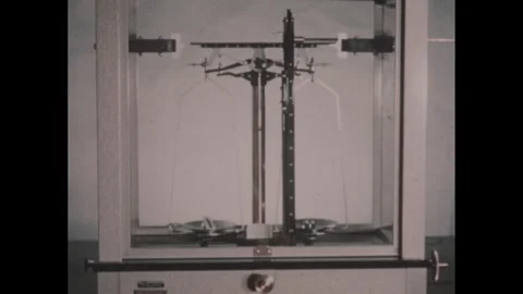 1950s: Hand points to balance scale in chamber. Hand points to laboratory Video stock 254443811