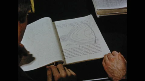 1950s: Hand points to chart in book. Women working in office. Hands look through Video stock 130357951