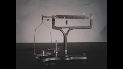 1950s: Hand points to copper weight on balance scale. Hand holds copper weight Stock Footage 254443940