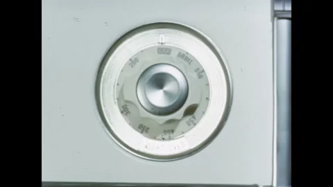 1950s: Hand turns knobs on stove. Salesman removes cookies from oven. Indian 스톡 동영상 165425905