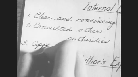 1950s: Hand writes words into book with a pen. View of name of man. Stock Footage