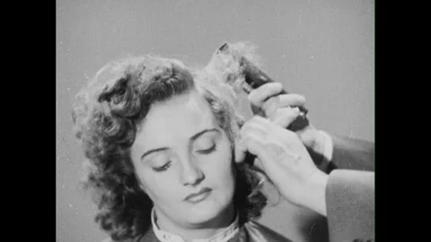 1950s: hands with comb and scissors shape, comb, pull woman's hair, comb Stock Footage 296503457
