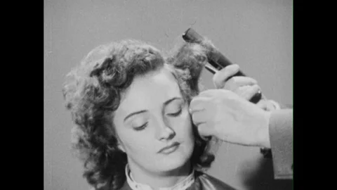 1950s: hands with comb and scissors shape, part, comb and pull woman's hair, Stock Footage 296503462