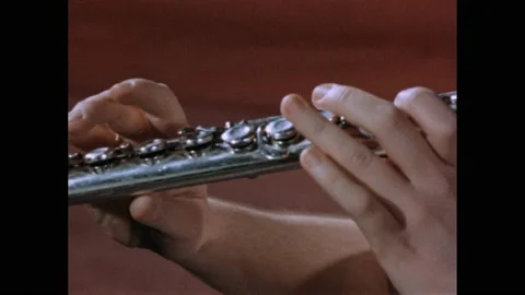 1950s: Hands holding flute, playing. Fingers depressing keys on instrument. Video stock 169181742