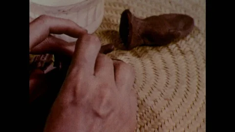 1950s: Hands spread paste on torn strips of paper and glue them to puppet hands. Stock Footage 123547328