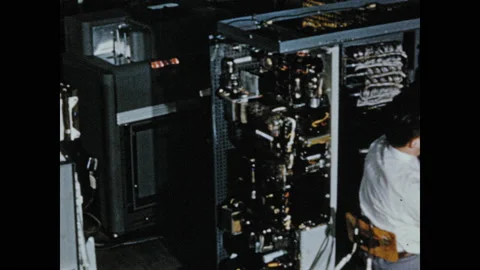 1950s: High angle tracking shot, men assembling computing machines. Vidéo 130357859