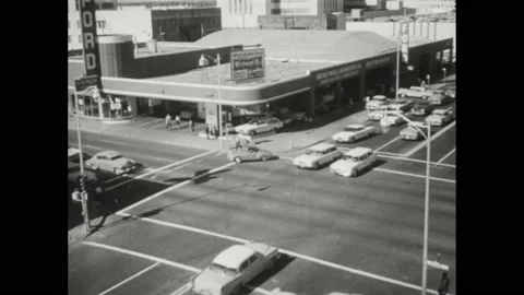 1950s: High angle view, traffic in intersection. Man shaking head. Scratches on Stock Footage 168387310