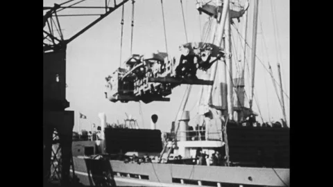 1950s: horses pulling plow, men unloading boxes, crane loading large metal Stock Footage 248620469