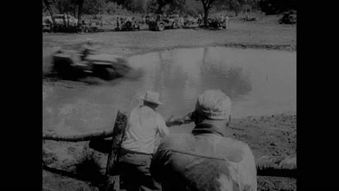 1950s: Jeeps driving through mud. Woman wiping mud from face. Men filming Jeep Stock Footage 159004113