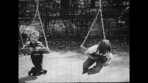 1950s: Kids play on swings. Children pla... | Stock Video | Pond5
