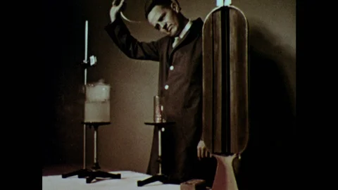 1950s: Lab.  Man takes off protective mask.  Smoke rises from beaker.  Man 動画素材 124817141
