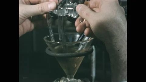 1950s: Lab.  Man turns knobs.  Liquid in glass beaker.  Hand holds paper 스톡 동영상 211283341