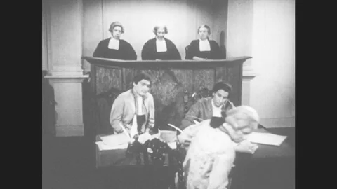1950s: Lawyer sits. Man stands. Man bows to judges and jury. Man gestures and Stock Footage