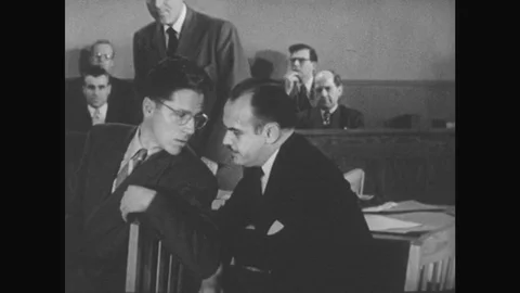 1950s: Lawyer talks to client during trial then gets up and addresses witness on Stock Footage