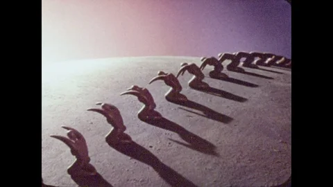 1950s: A line a clay figures bow toward the sun, rising on the horizon. Stock Footage 82625972