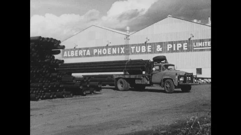 1950s: Load of pipe is transported from Alberta Phoenix Tube and Pipe company. Stock Footage 126010293