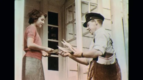 1950s: A mail man delivers mail to the doorstep of a house. Video stock 74502325