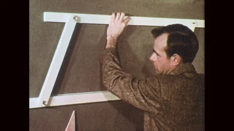 1950s: Man chalks dotted line using parallelogram template. Woman uses parallel Stock Footage 78493233