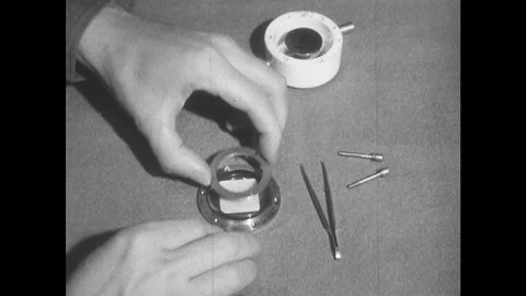 1950s: Man disassembles oscillator, picks up sheet of quartz with tweezers, Stock Footage 89858198