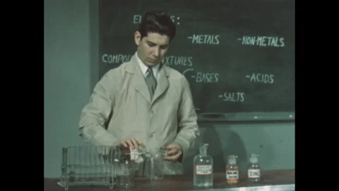 1950s: man in lab coat puts test tube in rack, pours clear liquids from 2 glass Stock Footage 279488254