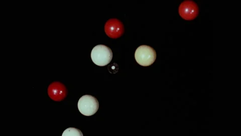 1950s: Man lines up a shot on a pool table. Red and white pool balls represent Stock Footage 152992387