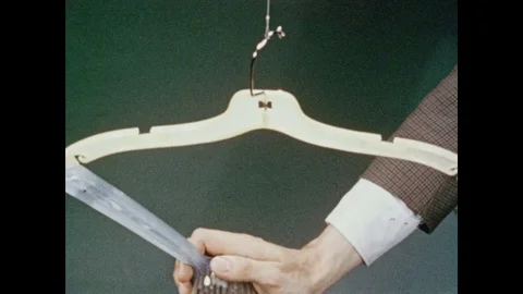 1950s: Man manipulates objects with precision, controlling hanger's movements in Video stock 84860249