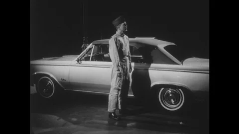 1950s: Man in military uniform stands by vintage car. Man in military uniform Stock Footage