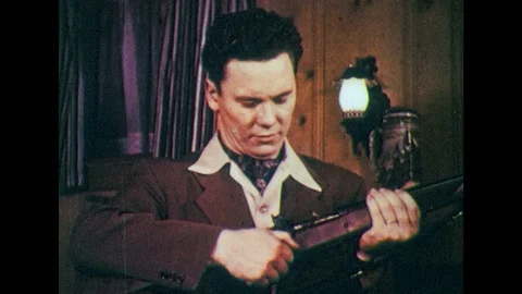 1950s: Man opens rifle, points to part. Men walk away from car with rifles. Stock Footage