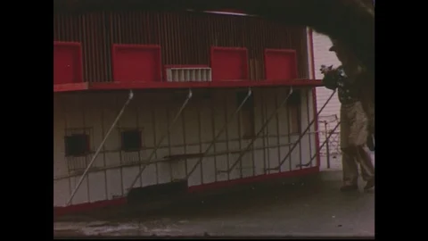 1950s: Man with pigeon next to bird cages / Man directs pigeon into cage / Man Stock Footage