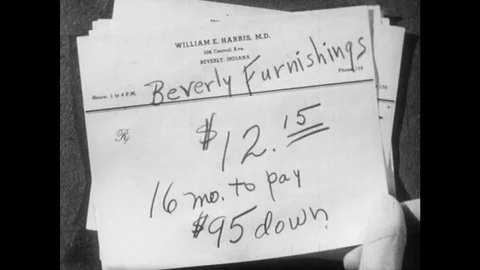 1950s: Man puts note on finance terms on desk. Man sits at desk, thinks. Vídeo Stock 82700740