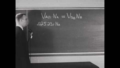 1950s: Man slowly adding values to the equation on the chalkboard. Stockbeeldmateriaal 241509031