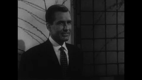1950s: Man in suit looks off. Woman sleeps in bed. Man tosses and turns in Stock Footage