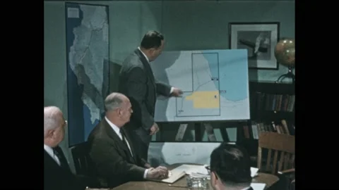 1950s: Man in suit shows map of Chicago waterfront to boardroom meeting. Vídeos de archivo 238929544