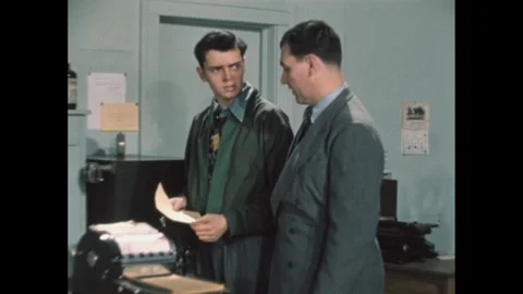 1950s: Man talking to boy in office by mimeograph machine, man exits. 스톡 동영상 284028177