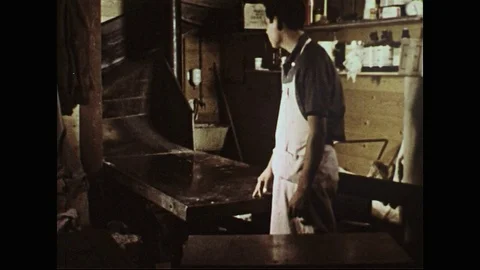 1950s: Man unloads boxes from chute / Boxes on chute / Boxes fall down chute. Video stock 74570226