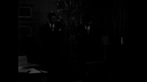 1950s: Man walks around store, looks at furniture, salesman talks to man. Man Vídeo Stock 82700712