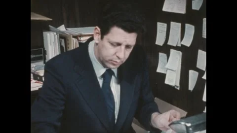 1950s: Man works on adding machine at desk in small office. Stock Footage 286713720