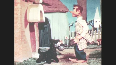 1950s: Marionette puppet pets dog, walks away. Puppet walks into house, dog Stock Footage
